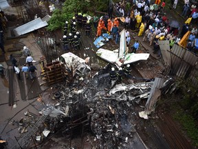 Indian rescue workers and firemen gather around the wreckage of a small plane that crashed into a construction site, killing five people, in Mumbai on June 28, 2018. (INDRANIL MUKHERJEE/AFP/Getty Images)
