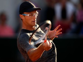 Canada's Peter Polansky plays a forehand return to France's Pierre-Hugues Herbert during their men's singles first round match on day three of The Roland Garros 2018 French Open tennis tournament in Paris on May 29, 2018.