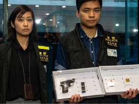 Police officers display a seized handgun and ammunition as evidence after a woman shot and wounded four people at a park in Taikoo Shing in Hong Kong on June 26, 2018.  At least four people were injured in a shooting at a park in Hong Kong on June 26, police said, a rare attack in the southern Chinese city which has a reputation for safety.