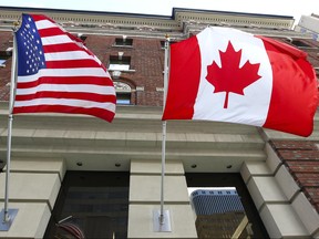The Canadian flag flies alongside the United States flag outside an Ottawa hotel Sept 26, 2012. (Andre Forget/QMI Agency)