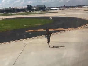 A man runs toward a plane at Atlanta airport in this screen grab. (Twitter)