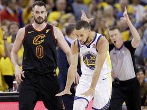 Golden State Warriors guard Stephen Curry celebrates in front of Cleveland Cavaliers forward Kevin Love (0) during Game 1 of the NBA Finals in Oakland, Calif., Thursday, May 31, 2018.