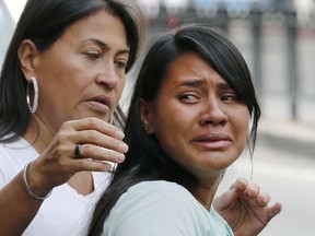 Barbara Barca, right, a survivor of the stampede at a crowded nightclub, cries as she leaves police headquarters in Caracas, Venezuela, Saturday, June 16, 2018. Venezuela's government says 17 people were killed early Saturday after a tear gas device was set off during a nightclub brawl in the capital, leading hundreds of people to flee.