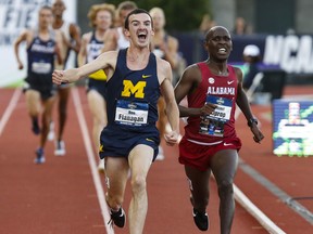 Michigan's Ben Flanagan begins to celebrate his NCAA title in the men's 10,000 meters as he passes Alabama's Vincent Kiprop near the finish line during the first day of the NCAA Outdoor Track and Field Championships Wednesday, June 6, 2018, at Hayward Field in Eugene, Ore. (Andy Nelson/The Register-Guard via AP)