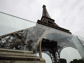 View of a new security bulletproof glass barrier under construction around the Eiffel Tower in Paris, France, Thursday, June 14, 2018. Paris authorities have started replacing the metal security fencing around the Eiffel Tower with a more visually appealing glass wall. The company operating the monument said see-through panels are being set up instead of the fences at the north and south of the famed monument that were installed for the Euro 2016 soccer event. Each panel is 3 meters high, over 6 centimeters thick and weighs 1.5 ton. (AP Photo/Francois Mori)