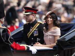 Britain's Prince Harry, left, and Meghan, Duchess of Sussex ride in a carriage to attend the annual Trooping the Colour Ceremony in London, Saturday, June 9, 2018.