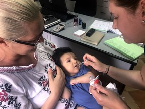 In this photo taken on Wednesday, June 6, 2018, a child gets a dose of vaccine in Chitila, Romania.