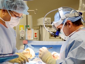 Dr. Scott Sullivan (right), a plastic surgeon at the Center for Restorative Breast Surgery in New Orleans, performs breast reconstruction on patient Karen Kozlowski on Jan. 18, 2012. (Thandi Fletcher/Calgary Herald)