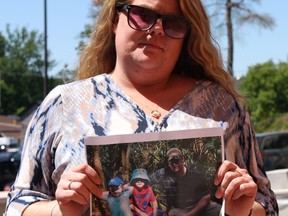 Casey Mackinlay holds up a photo of her late common-law husband Corby Stott. (Tracy McLaughlin/Toronto Sun/postmedia)