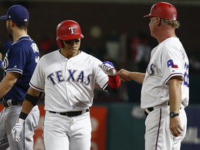 Texas Rangers' Shin-Soo Choo, left, celebrates his base hit with hitting coach Steve Buechele Tuesday, June 26, 2018, in Arlington, Texas. Choo reached base for the 39th consecutive game on the play. (AP Photo/Jim Cowsert)