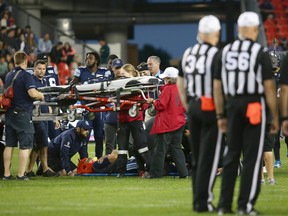 Coaching staff and players gather around Toronto Argonauts quarterback Ricky Ray (15) as he lays injured on the field during the second half of CFL football game action against the Calgary Stampeders at BMO Field in Toronto on Saturday June 23, 2018. THE CANADIAN PRESS/Cole Burston