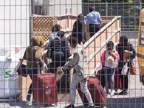 A group of asylum seekers arrive at the temporary housing facilities at the border crossing Wednesday May 9, 2018 in St. Bernard-de-Lacolle, Que. As the United States faces mounting criticism over its treatment and detention of illegal migrants, new statistics released by the Canadian government offer a contrast to the way Canada treats its illegal border crossers. THE CANADIAN PRESS/Ryan Remiorz