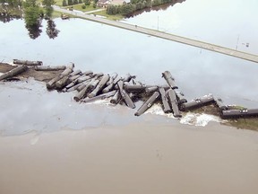 In this aerial drone image taken from video and provided by the Sioux County Sheriff's Office, tanker cars carrying crude oil are shown derailed about a mile south of Doon, Iowa, Friday, June 22, 2018. About 31 cars derailed after the tracks reportedly collapsed due to saturation from flood waters from adjacent Little Rock River. (Sioux County Sheriff's Office via AP)
