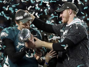 In this Feb. 4, 2018 photo, Philadelphia Eagles quarterback Carson Wentz, right, hands the Lombardi trophy to Nick Foles after winning Super Bowl 52 in Minneapolis. (AP Photo/Frank Franklin II)