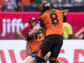 Lions' Marcell Young (8) knocks down a spectator that ran onto the field of play during the first half  CFL action against the Alouettes in Vancouver, on Saturday June 16, 2018.
