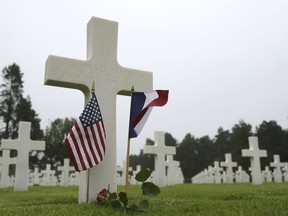 US and French flags and a flower are placed on the grave ofJames D. Black, from New York, who died on June 11, 1944, at the Colleville American military cemetery, in Colleville sur Mer, western France, Wednesday June 6, 2018, on the 74th anniversary of the D-Day landing.