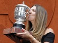 Romania's Simona Halep kisses with the cup at the Roland Garros stadium, Sunday, June 10, 2018 in Paris. Halep won Saturday the French Open tennis tournament women's final. (AP Photo/Thibault Camus)