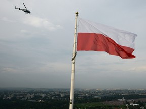 This picture shows a Polish flag while a police helicopter flies over the Blonia Meadows in Krakow, on July 26, 2016, where pilgrims from all over the world celebrate the Opening Mass on the first day of the World Youth Days. (Bartosz Siedlik/Getty Images)