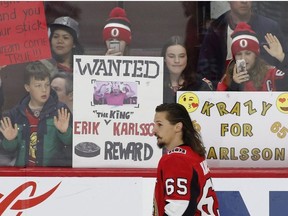 Fans hold up signs in support of Ottawa Senators captain Erik Karlsson (65) during the warm-up before NHL hockey action against the Winnipeg Jets at the Canadian Tire Centre in Ottawa on Monday, April 2, 2018.