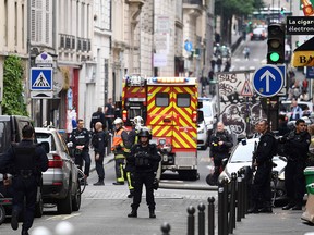Police officers stand on a street near the site of an ongoing hostage taking on June 12, 2018 in central Paris.