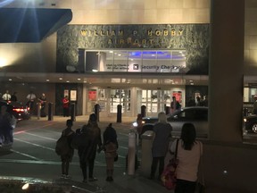 People wait outside Houston's William P. Hobby Airport on Thursday, June 7, 2018, after a toy grenade in a passenger's bag forced the shutdown of a security checkpoint, inconveniencing hundreds of people catching early-morning flights. (AP Photo/John L. Mone)