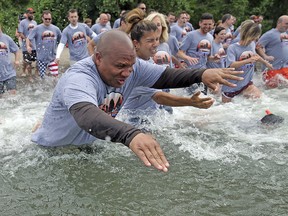 Cleveland Browns head coach Hue Jackson, owner Dee Haslam and other Browns employees run into Lake Erie to take the 0-16 plunge he promised, Friday, June 1, 2018 in Bay Village, Ohio. (Joshua Gunter/The Plain Dealer via AP)