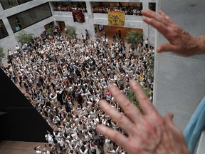 Protesters hold up their hands as they fill the center atrium and upper levels lining the Hart Senate Office Building in protest of the separation of immigrant families, Thursday, June 28, 2018, on Capitol Hill in Washington.