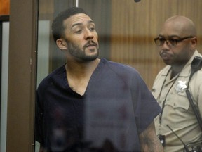 Former NFL football player Kellen Winslow Jr., center, looks through protective glass during his arraignment Friday, June 15, 2018, in Vista, Calif.