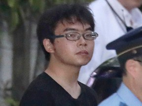 Knife attack suspect Ichiro Kojima, escorted by police, leaves Odawara police station after being arrested in Odawawa, southwest of Tokyo, Sunday, June 10, 2018. Police say they arrested Kojima after a bullet express train made an unscheduled stop late Saturday at Odawara station following a knife attack on the train that has left one passenger dead and two others injured. (Kyodo News via AP)