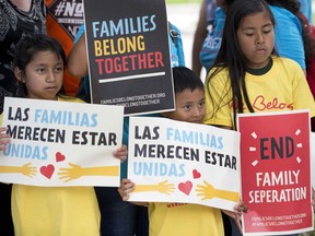 In this June 1, 2018, file photo, children hold signs during a demonstration in front of the Immigration and Customs Enforcement offices in Miramar, Fla.