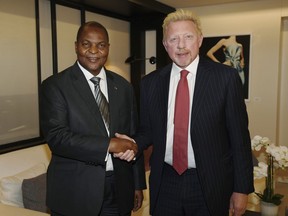 In this file photo originally released on Friday, April 27, 2018, President Prof. Faustin Archange Touadera, left, shakes hands with retired German tennis star Boris Becker in Brussels, Belgium, after it was announced Becker has been appointed by the Central African Republic as its Attache for Sports and Humanitarian and Cultural Affairs in the European Union with immediate effect.   (Irle Moser Rechtsanwalte PartG via AP Images, FILE)