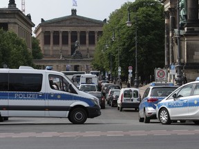 Police vehicles stand in front of Berlin Cathedral, Sunday June 3, 2018. Berlin police say an officer has opened fire near the German capital's cathedral, slighting injuring a man.