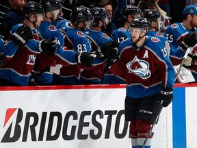 Colorado Avalanche centre Nathan MacKinnon, front, is congratulated after scoring a goal against the Nashville Predators as he passes the team box in the second period of Game 3 of an NHL hockey first-round playoff series Monday, April 16, 2018, in Denver.