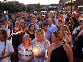 Mourners stand in silence during a vigil in response to a shooting at the Capital Gazette newsroom, Friday, June 29, 2018, in Annapolis, Md.