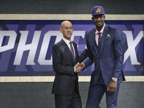 Arizona's Deandre Ayton, right, poses with NBA Commissioner Adam Silver after he was picked first overall by the Phoenix Suns during the NBA basketball draft in New York, Thursday, June 21, 2018.