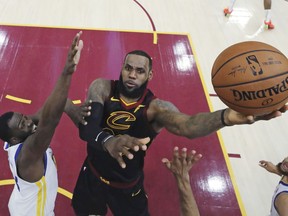 In this June 6, 2018, file photo, Cleveland Cavaliers' LeBron James shoots against Golden State Warriors' Draymond Green during the first half of Game 3 of basketball's NBA Finals in Cleveland.