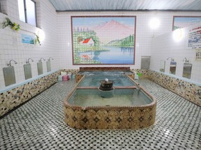 This undated photo provided by Stéphanie Crohin shows traditional baths and murals in Kasuga onsen, or hot spring bath, in Matsuzaka, Mie prefecture, Japan. Japan is proud of its bathing traditions. For many Westerners, though, the fact that these traditions involve being naked with strangers is awkward at best, even though men and women bathe separately.