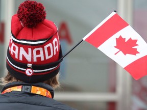 A Member of Team Canada wears a flag on his hat as he takes part in the flag raising at the athletes' village in Pyeongchang, Republic of Korea on Wednesday March 7, 2018. (Scott Grant/The Canadian Press/HO-Canadian Paralympic Committee)
