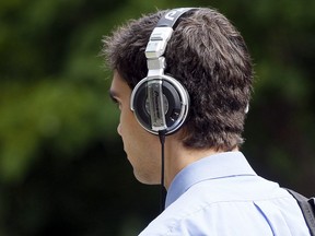 A man walks wearing large headphones in downtown Ottawa Tuesday, August 2, 2011. (Darren Brown/Sun Media)