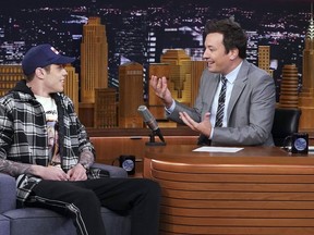 This image released by NBC shows comedian Pete Davidson, a cast member on "Saturday Night Live," left, with host Jimmy Fallon during a taping of "The Tonight Show Starring Jimmy Fallon," Wednesday, June 20, 2018, in New York where he confirmed that he is engaged to singer Ariana Grande.