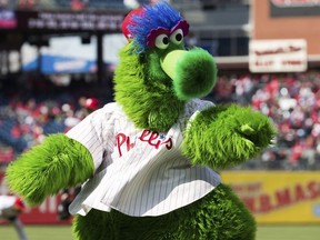 In this April 5, 2018 photo, The Phillie Phanatic reacts prior to the first inning of a baseball game against the Miami Marlins  in Philadelphia.   Kathy McVay says she was at Monday, June 18,  Phillies game when the team's mascot, the Phillie Phanatic, rolled out his hot dog launcher. McVay was sitting near home plate and all of a sudden she says a hot dog wrapped in duct tape struck her in the face.  She left the game to get checked out at a hospital, and she says she has a small hematoma.  The Phillies apologized to McVay Tuesday and the team has offered her tickets to any game.