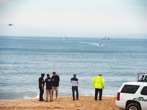 Members of the New York State park police look near the scene of a plane crash in the ocean off Indian Wells Beach in Amagansett, N.Y., Saturday, June 2, 2018.
