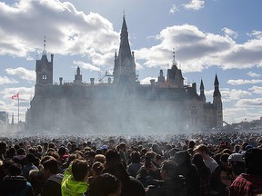 Smoke lingers over Parliament Hill as people smoke marijuana during the annual 4/20 rally on Parliament Hill in Ottawa, Ontario on April 20, 2018.  AFP PHOTO