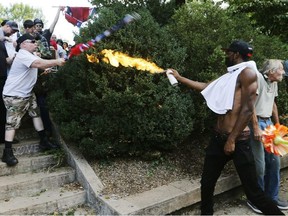 In this Aug. 12, 2017, file photo, counter demonstrator Corey Long points a lighted aerosol spray towards against a white nationalist demonstrator at the entrance to Lee Park in Charlottesville, Va. On Friday, June 8, 2018, Long was convicted of disorderly conduct for using the improvised flamethrower and ordered to serve 20 days in jail.