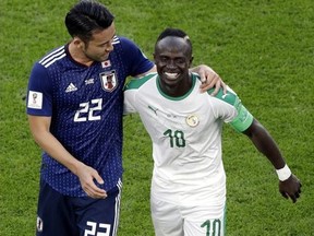 Japan's Maya Yoshida, left, shares a light moment with Senegal's Sadio Mane during Group H action at the 2018 World Cup at the Yekaterinburg Arena in Yekaterinburg , Russia, Sunday, June 24, 2018.