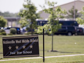 Law enforcement vehicles are seen behind a school sign after a shooting at Noblesville West Middle School in Noblesville, Ind. on May 25, 2018. (Robert Scheer/The Indianapolis Star via AP)