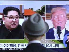 A man watches a TV screen showing file footage of U.S. President Donald Trump, right, and North Korean leader Kim Jong Un during a news program at the Seoul Railway Station in Seoul, South Korea, Monday, June 11, 2018.  Final preparations are underway in Singapore for Tuesday's historic summit between President Trump and North Korean leader Kim, including a plan for the leaders to kick things off by meeting with only their translators present, a U.S. official said.  The signs read: " Summit between the United States and North Korea."