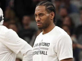 In this April 5, 2017, file photo, San Antonio Spurs forward Kawhi Leonard reacts to a play as he waits to enter the game during the first half of an NBA basketball game against the Los Angeles Lakers in San Antonio.