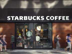 Pedestrians walk past a downtown Toronto Starbucks Coffee location on May 31, 2018.