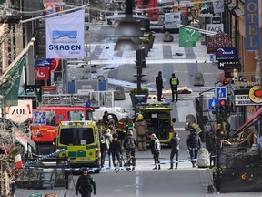 FILE This is a April 7, 2017 file photo, showing  emergency services at the scene of an attack on Drottninggatan street in central Stockholm. 2018. An Uzbek man who drove stolen truck into crowd in Stockholm, killing five people and wounding 14 others, has been convicted of terror-related murder and given a life sentence on Thursday, June 7, 2018. Rakmat Akilov had said he wanted to punish Sweden for joining a coalition against the Islamic State group.